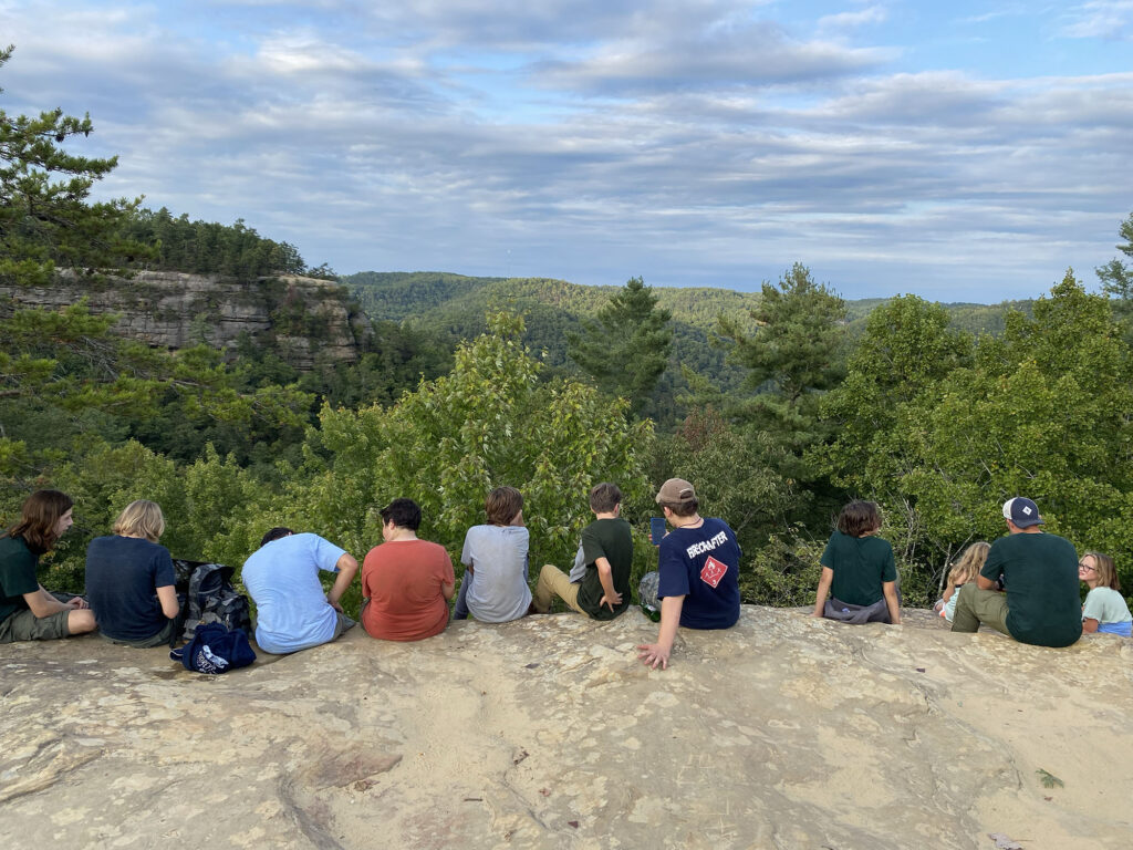 Group of scouts sitting on overlook of wilderness area